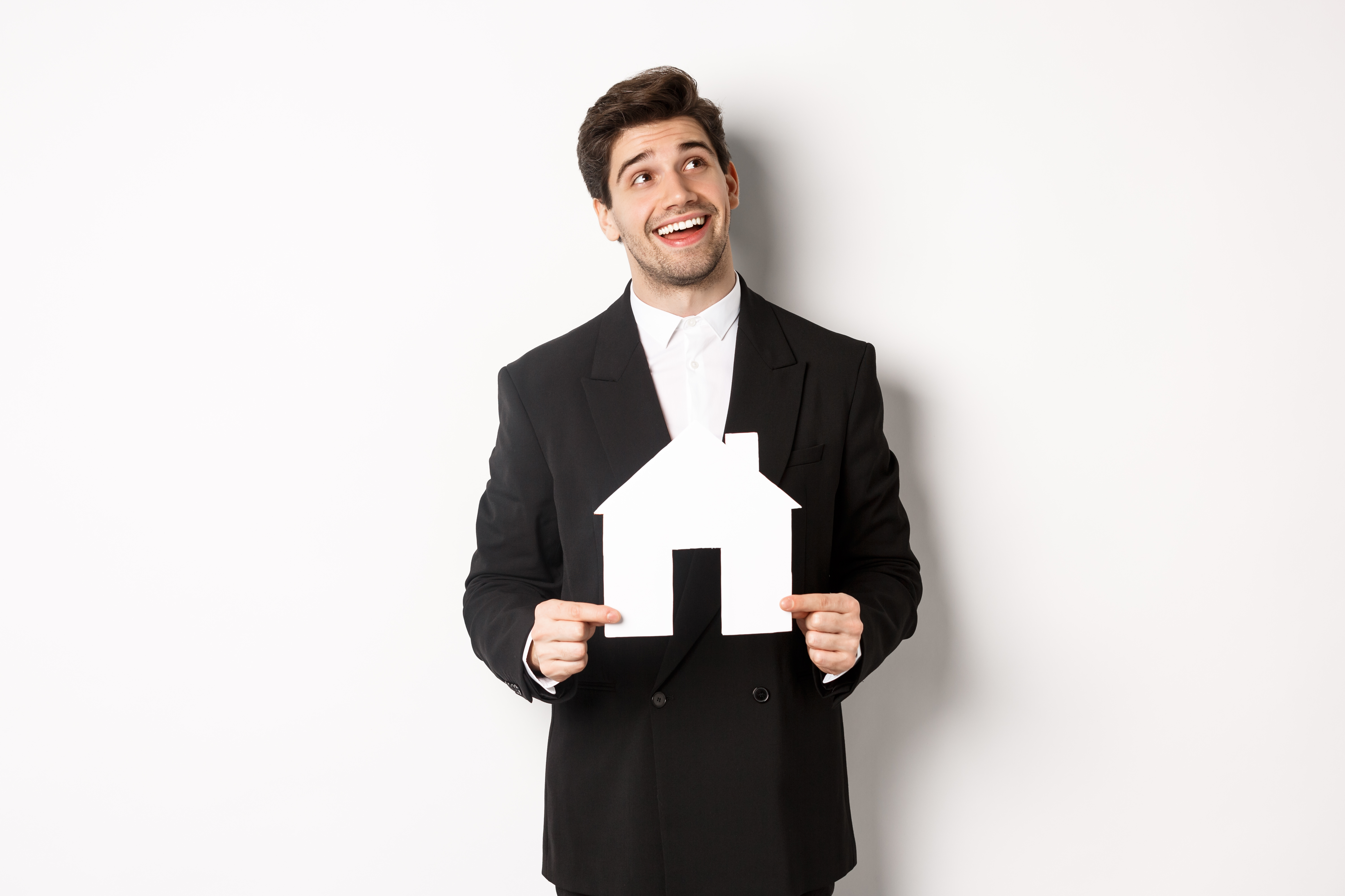 Portrait Handsome Man Suit Searching Home Holding Paper House Looking Upper Right Corner Dreamy Standing White Background