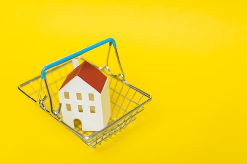Overhead View House Model Inside Shopping Cart Against Yellow Background Min